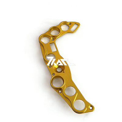 Gold CNC-machined metal button plate for Ascher Wheels, featuring multiple circular and rectangular cutouts for sim racing setups.
