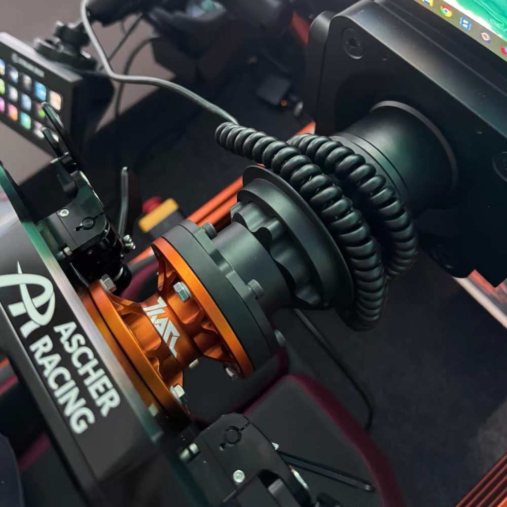 Orange and black KARL extension spacer installed in sim racing cockpit