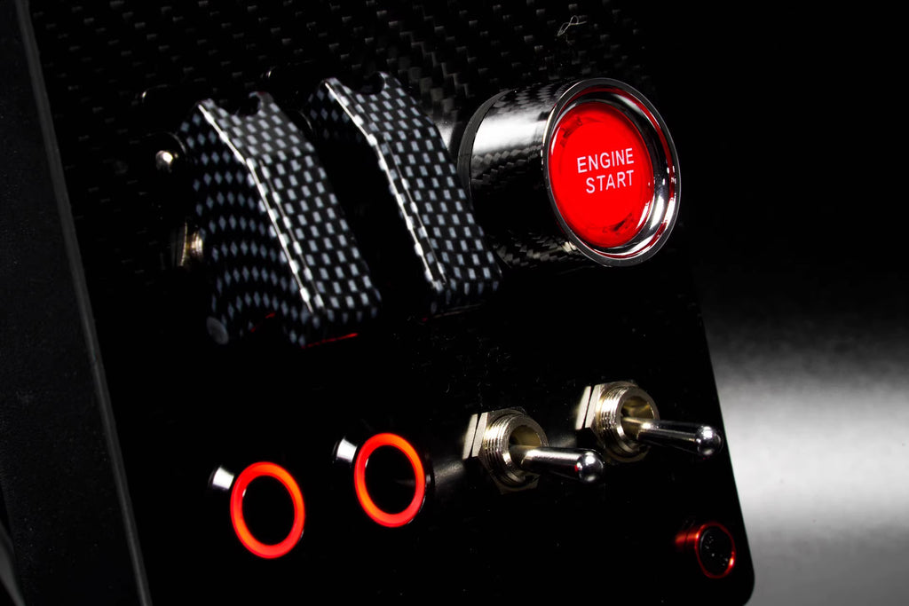 Sim racing button box with red Engine Start button, carbon fiber switches, and illuminated controls
